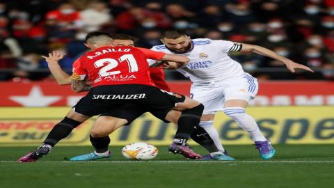 الفرنسي كريم بنزيمة قائد نادي ريال مدريد وهو يحاول الحفاظ على الكرة خلال المباراة أمام ريال مايوركا في الدوري الإسباني. (أ ف ب).jpeg