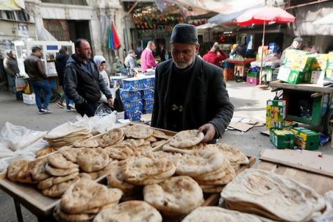 فلسطينيون يشترون الخبز وسط ارتفاع اسعار الطحين بسبب موجة الغلاء العالمية في مدينة نابلس.