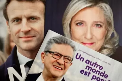 ملصقات انتخابية في 6 نيسان/ابريل 2022 في مرسيليا بجنوب فرنسا تظهر المرشحين الرئيس ايمانويل ماكرون (يسار) ومارين لوبن وجان لوك ميلانشون (وسط). afp