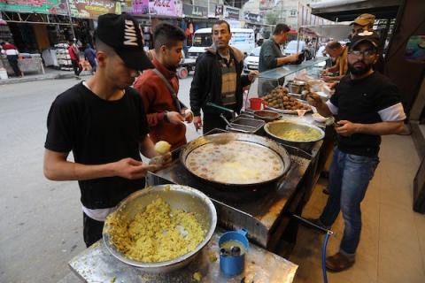 فلسطينيون يتسوقون في أحد الأسواق خلال شهر رمضان المبارك في مخيم المغازي للاجئين وسط قطاع غزة