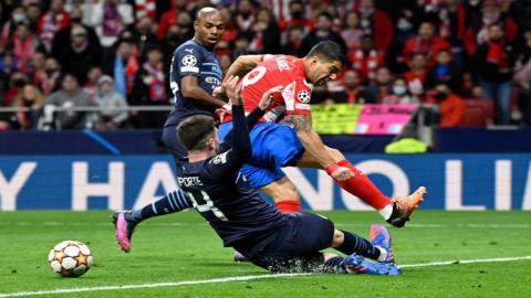 مدافع مانشستر سيتي الإسباني إيمريك لابورتي يواجه مهاجم أوروغواي لويس سواريز (يمين) خلال مباراة إياب ربع نهائي دوري أبطال أوروبا بين نادي أتلتيكو مدريد ومانشستر سيتي في مدريد. 13/04/2022. (أ ف ب)