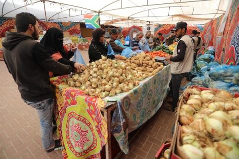 فلسطينيون يتسوقون من السوق الخيري للمواد الغذائية والخضروات واللحوم للأسر المحتاجة في محافظة خانيونس
