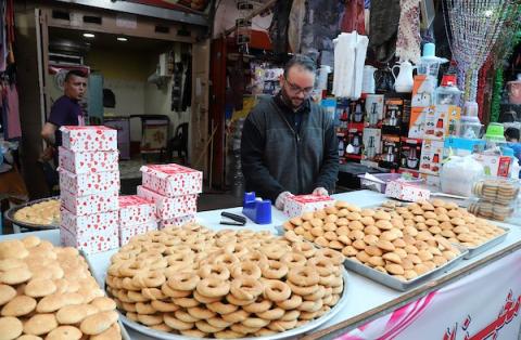 فلسطينيون يتسوقون في أحد الأسواق قبل عيد الفطر ، احتفالاً بنهاية شهر رمضان المبارك في مخيم النصيرات