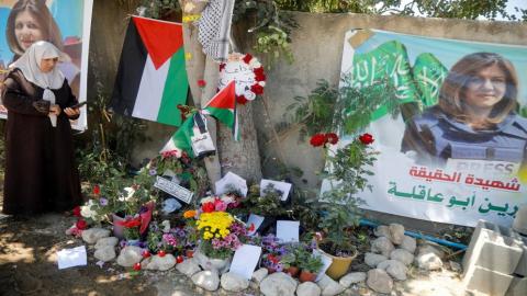 امرأة فلسطينية تلتقط صورا في مكان استشهاد مراسلة الجزيرة شيرين أبو عاقلة في جنين، 17 أيار/مايو 2022. (رويترز / رنين صوافطة)