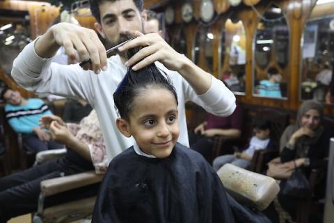 الفلسطينيون يقصون شعورهم داخل محل لتصفيف الشعر في مدينة خانيونس استعدادا لعيد الفطر 12.jpg