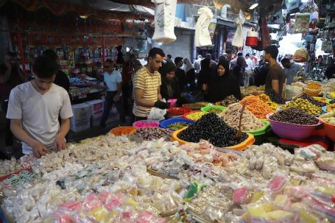 فلسطينيون يتسوقون استعداداً لعيد الفطر في سوق الزاوية في مدينة غزة