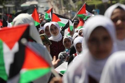 فلسطينيات يشاركن في مسير الأعلام الفلسطينية خلال انطلاق مخيمات مواكب سيف القدس القرآنية في مدينة غزة