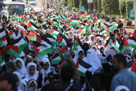 فلسطينيات يشاركن في مسير الأعلام الفلسطينية خلال انطلاق مخيمات مواكب سيف القدس القرآنية في مدينة غزة