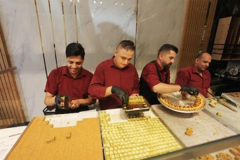 فلسطينيون يشترون الحلويات بعد ظهور نتائج الثانوية العامة في مدينة غزة.