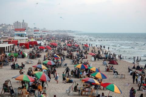 المواطنون الفلسطينيون يصطافون على شاطئ بحر مدينة غزة خلال يوم العطلة.jpg