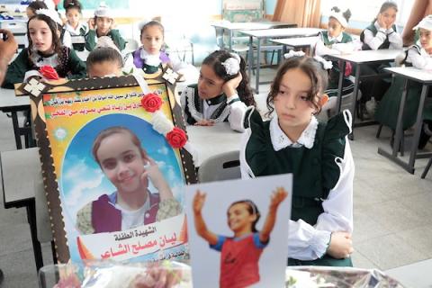 طلاب فلسطينيون يضعون صور الطفلة ليان الشاعر التي استشهدت خلال العدوان الإسرائيلي الأخير على قطاع غزة، على مقعدها الدراسي في اليوم الأول من العام الدراسي الجديد في مدينة خان يونس جنوب قطاع غزة