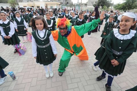 مهرجون فلسطينيون يشاركون في فعاليات التفريغ النفسي للطلبة خلال اليوم الأول من العام الدراسي الجديد في خان يونس جنوب قطاع غزة