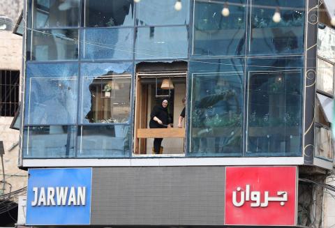 فلسطينيون ينظفون الشوارع بعد عودة الهدوء إلى مدينة نابلس بالضفة الغربية.jpg