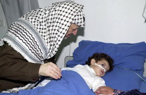 الرئيس الراحل ياسر عرفات أثناء زيارته لجرجى انتفاضة الأقصى.jpg