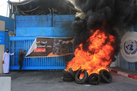فلسطينيون أصحاب المنازل المدمرة يحرقون الاطارات خلال وقفة احتجاجية للمطالبة باعادة بناء منازلهم أمام مقر وكالة الأونروا في مدينة غزة