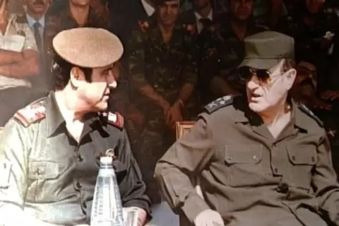 صورة مملتقطة في الأول من كانون الثاني/يناير 1984 تظهر الرئيس السوري الراحل حافظ الأسد (يمين) إلى جانب شقيقه الأصغر رفعت الأسد (يسار)خلال مراسم عسكرية في دمشق afp