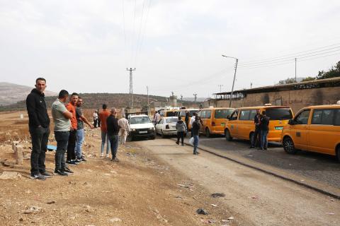 سائق سيارة فلسطيني يدخن النرجيلة وهو داخل مركبته في انتظار عبور حاجز تفتيش إسرائيلي بين مدينة نابلس الفلسطينية وقرية بيت فوريك في الضفة الغربية 7.jpg