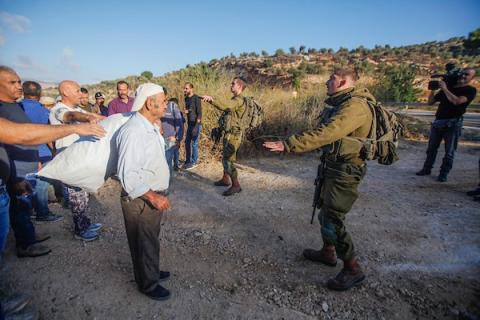 المزارعون الفلسطينيون ينتظرون فتح الحواجز العسكرية من قبل جيش الاحتلال للتوجه إلى أراضيهم وقطف الزيتون في قرية سالم شرق مدينة نابلس 2.jpg