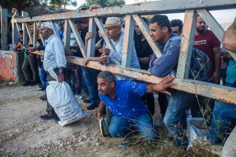 المزارعون الفلسطينيون ينتظرون فتح الحواجز العسكرية من قبل جيش الاحتلال للتوجه إلى أراضيهم وقطف الزيتون في قرية سالم شرق مدينة نابلس.jpg