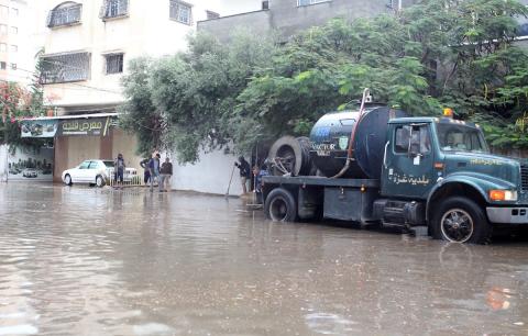 عمال البلدية تقوم بإزالة مياة الأمطار، في مدينة غزة