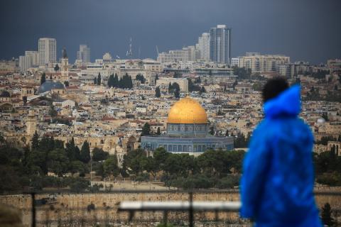 فلسطيني ينظر إلى قبة الصخرة خلال يوم غائم في مدينة القدس.jpg