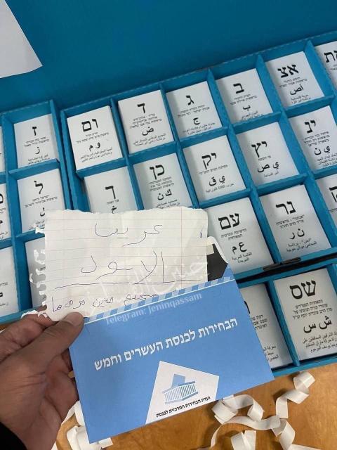 أحد المقترعين في الانتخابات الإسرائيلية يترك رسالة ورقية في كبينة الانتخاب مخطوط عليها