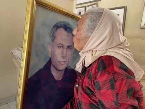 والدة كريم يونس الحاجة صبحية تقبل صورته قبل رحيلها