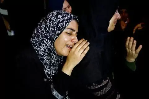 عائلة الفلسطيني محمد الشاعر الذي توفي عندما غرقت سفينة تقل مهاجرين تنتحب خلال توديع جثمانه قبل دفنه في رفح جنوب قطاع غزة . تصوير: إبراهيم أبومصطفى - رويترز