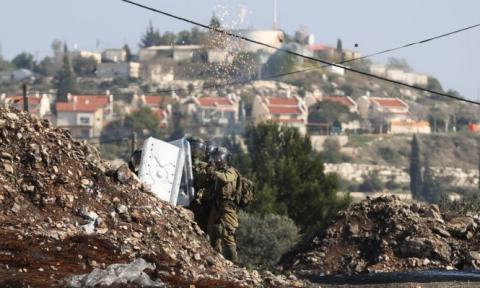 جنود الاحتلال يطلقون قنابل الغاز باتجاه فلسطينيين عند مستوطنة قرب قلقيليا أول من أمس (Getty Images).jpg