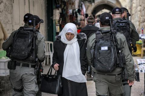مواطنة تمر من وسط عناصر لقوات الاحتلال الإسرائيلي في البلدة القديمة من مدينة القدس المحتلة (أرشيف - أ ف ب).jpg