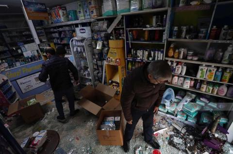 مواطنون يتفقدون آثار الدمار الذي لحق بصيدلية قريبة من مكان العملية التي نفذتها قوات الاحتلال الاسرائيلي.jpg