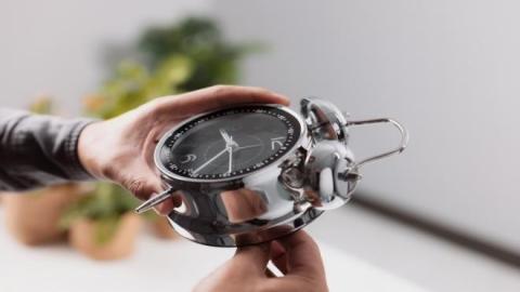 صورة توضيحية لشخص يعدّل الوقت على الساعة. (shutterstock).jpg