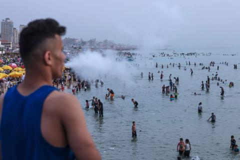 أهالي قطاع غزة يهربون من الحر الشديد الذي يلازم منازلهم في ظل انقطاع الكهرباء إلى شواطئ البحر المتنفس الوحيد لهم .. تصوير (الفرنسية).jpg