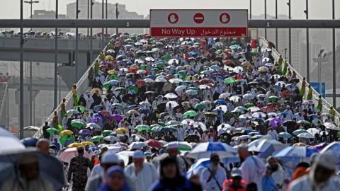 حجّاج كثر لجأوا إلى المظلات لحماية أنفسهم من ضربات شمس (حجاج حسين- فرانس برس).jpg