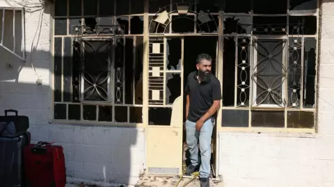 فلسطيني يستعد للخروج من منزله المحترق في قرية ترمسعيا والتي شهدت هجوم مستوطنين أحمد غرابلي -  ا ف ب.webp