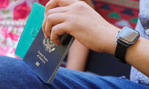 هاني المدهون فلسطيني يحمل جواز سفره الأمريكي بينما يجلس في منزله ببيت لاهيا في شمال غزة يوم الأربعاء. تصوير: محمد سالم - رويترز