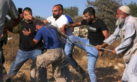 فلسطينيون يهاجمون مستوطنا إسرائيليا حاول الاستيلاء على أرضهم في بلدة حلحول بالضفة الغربية.jpg