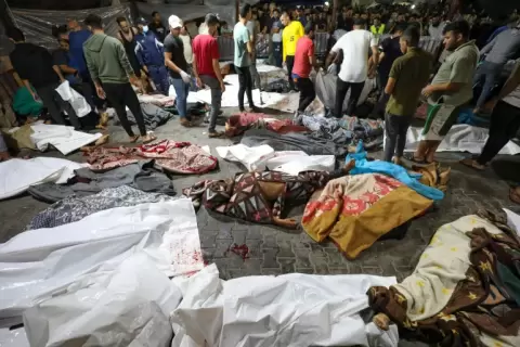 جمع من الناس حول جثث الفلسطينيين الذين قُتلوا بعد قصف المستشفى الأهلي بغزة في 17 أكتوبر-تشرين الأول 2023 (الفرنسية).webp