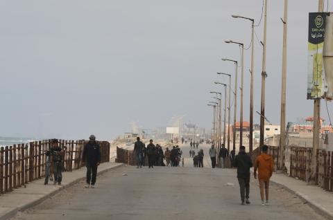 النازحون الفلسطينيون الفارون من المنطقة المحيطة بمستشفى الشفاء بمدينة غزة يصلون عبر الطريق الساحلي السريع إلى مخيم النصيرات للاجئين وسط قطاع غزة في 18 مارس 2024. تصوير: نعمان عمر