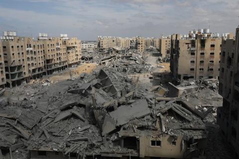 فلسطينيون يتفقدون الأضرار التي لحقت بالمباني المدمرة في مدينة حمد، إثر الهجوم الإسرائيلي على خان يونس بقطاع غزة في 14 مارس 2024. تصوير: نعمان عمر