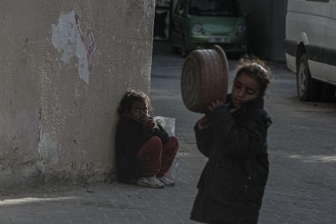 أطفال فلسطينيون يحاولون الحصول على بعض المواد الغذائية من إحدى الدور الخيرية في دير البلح وسط قطاع غزة. تصوير :عمر اشتيوي