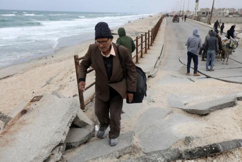 النازحون الفلسطينيون الفارون من المنطقة المحيطة بمستشفى الشفاء بمدينة غزة يصلون عبر الطريق الساحلي السريع إلى مخيم النصيرات للاجئين وسط قطاع غزة في 18 مارس 2024. تصوير: نعمان عمر