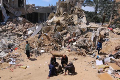 فلسطينيون يتفقدون الأضرار التي لحقت بمبنى بعد القصف الإسرائيلي خلال الليل في دير البلح، قطاع غزة، في 25 مارس 2024. تصوير سعيد جرس