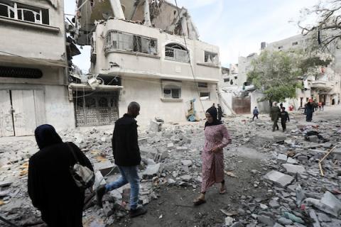 فلسطينيون يتجمعون لتفقد الأضرار التي لحقت بالمبنى المدمر التابع لعائلة العطار، في أعقاب الهجوم الإسرائيلي على مخيم البريج للاجئين، قطاع غزة، في 14 مارس 2024. تصوير: نعمان عمر