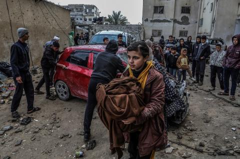 رفح: فتاة فلسطينية تحمل بعض ممتلكاتها وهي تسير بالقرب من المركبات المدمرة في أعقاب هجوم جوي إسرائيلي. عبد الرحيم الخطيب/ وكالة الأنباء الألمانية