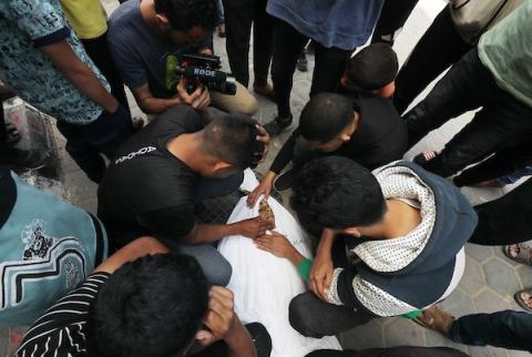 أقارب الفلسطينيين الذين قتلوا في الهجمات الإسرائيلية، يبكون أثناء استلامهم الجثث من مشرحة مستشفى الأقصى لدفنها في دير البلح، غزة في 22 أبريل 2024. تصوير: علي حمد