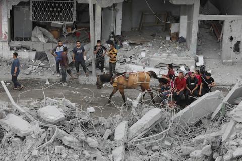 فلسطينيون يبحثون عن الجثث والناجين وسط أنقاض منزل مدمر في أعقاب غارة جوية إسرائيلية على مخيم النصيرات للاجئين، جنوب قطاع غزة، في 27 أبريل/نيسان 2024.. تصوير: عمر اشتياوي