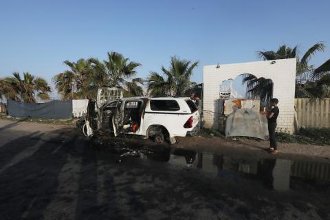 فلسطينيون يتفقدون المركبات المتضررة بشدة بعد الهجمات الإسرائيلية التي استهدفت المسؤولين العاملين في منظمة المساعدة التطوعية الدولية "المطبخ المركزي العالمي" World Central Kitchen (WCK)، في دير البلح، قطاع غزة، في 02 أبريل 2024 : تصوير : عمر اشتيوي