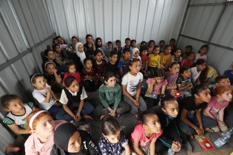 المعلم الفلسطيني محمد الخضري يراجع الدروس التربوية لطلابه النازحين في مخيم إيواء النازحين في دير البلح وسط قطاع غزة دير البلح – 28 إبريل 2024.. تصوير: نعمان عمر