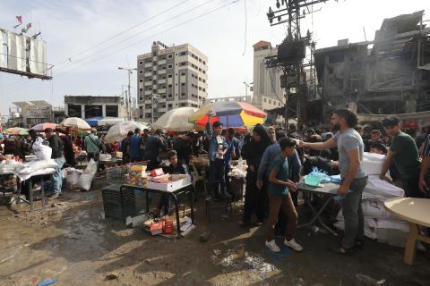 أشخاص يتسوقون من الباعة في سوق مفتوح وسط الدمار في النصيرات وسط قطاع غزة، 05 أبريل 2024. تصوير :نعمان عمر